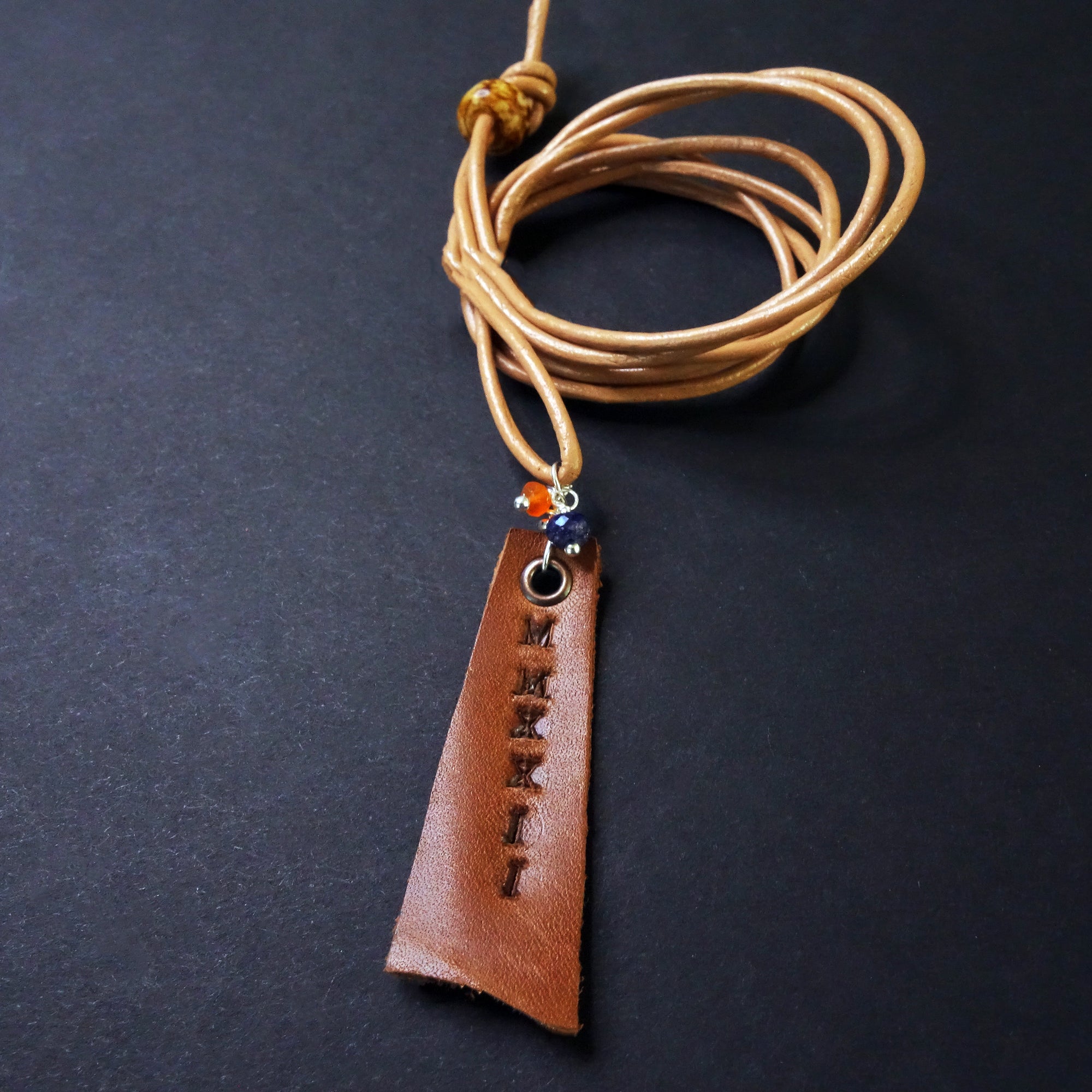 Leather stamped MMXXIV with school colors (gems)