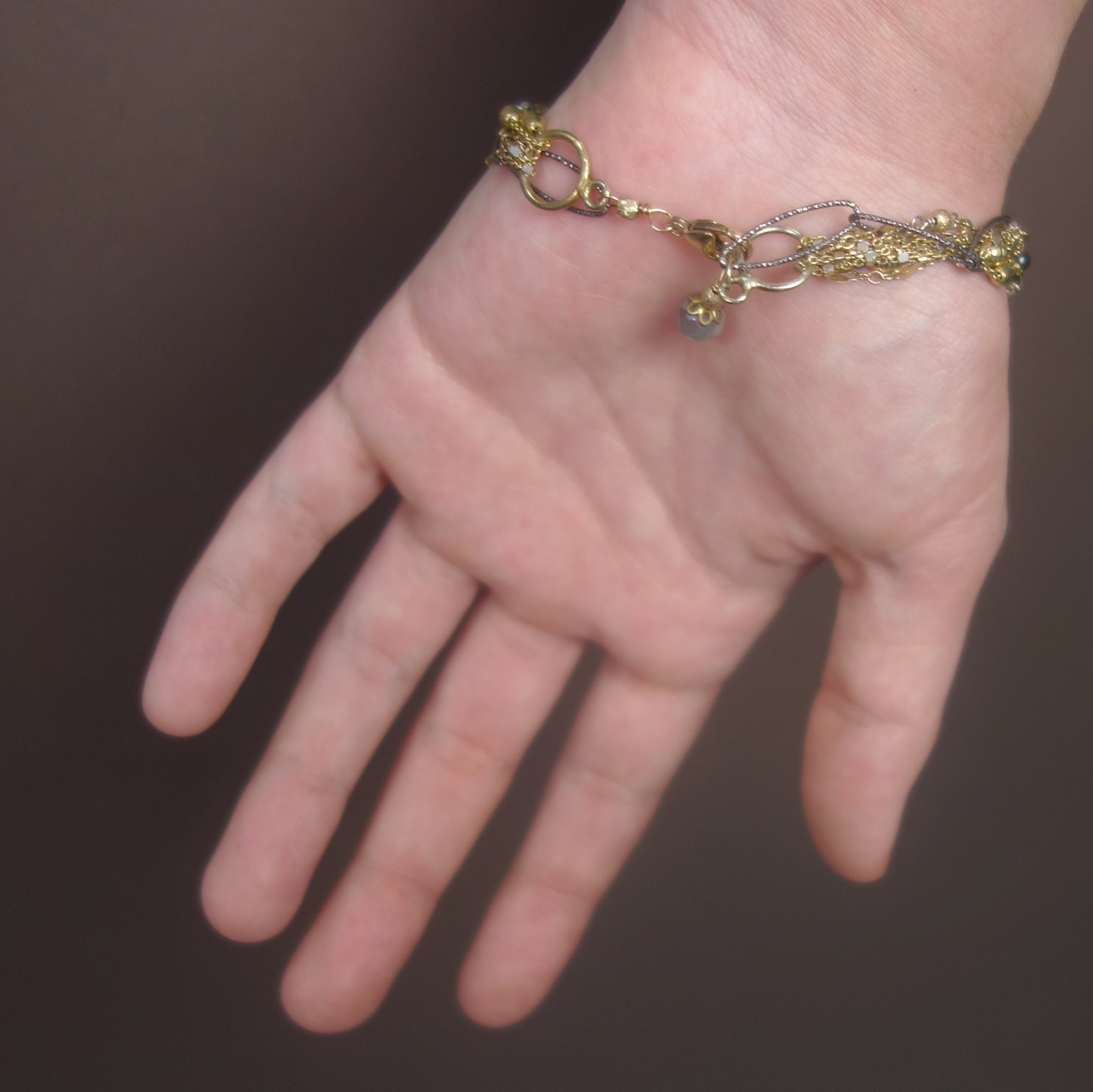 I've Seen Fire and Rain: emerald, gold, and silver bracelet