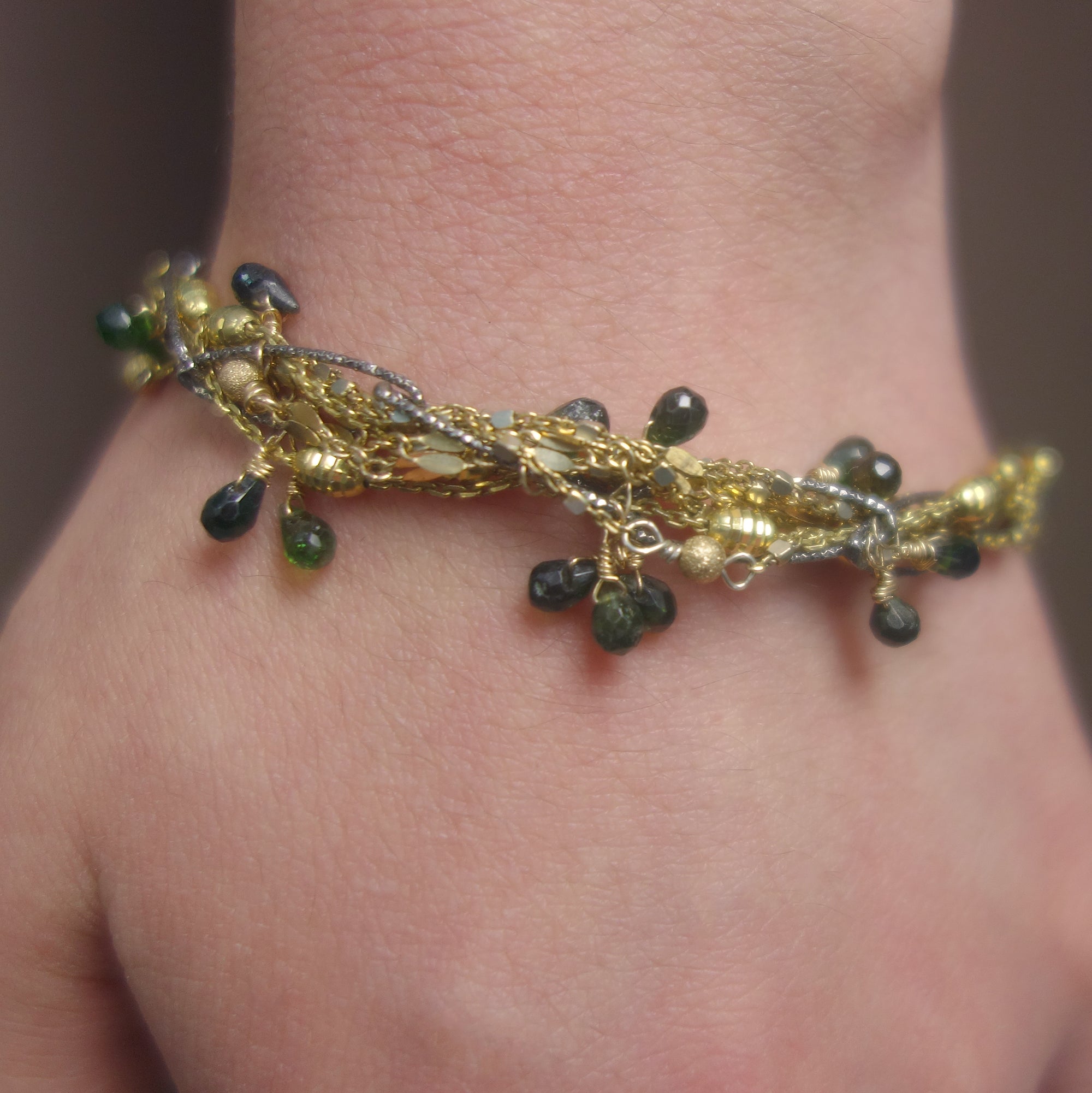 I've Seen Fire and Rain: emerald, gold, and silver bracelet
