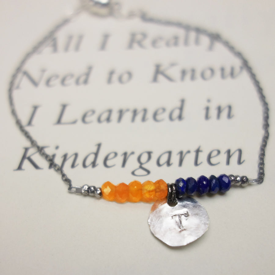 Grad's initial hand stamped in silver, school gemstones