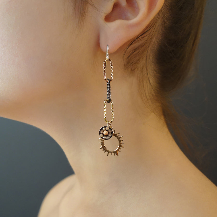 It's a New Dawn mosaic earring of gold, rose gold, and silver